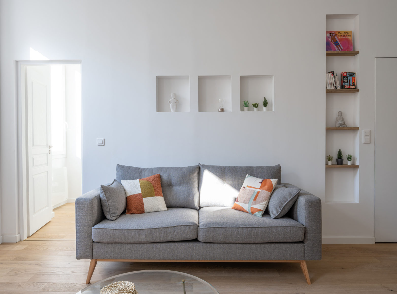 Salon avec canapé gris et niches