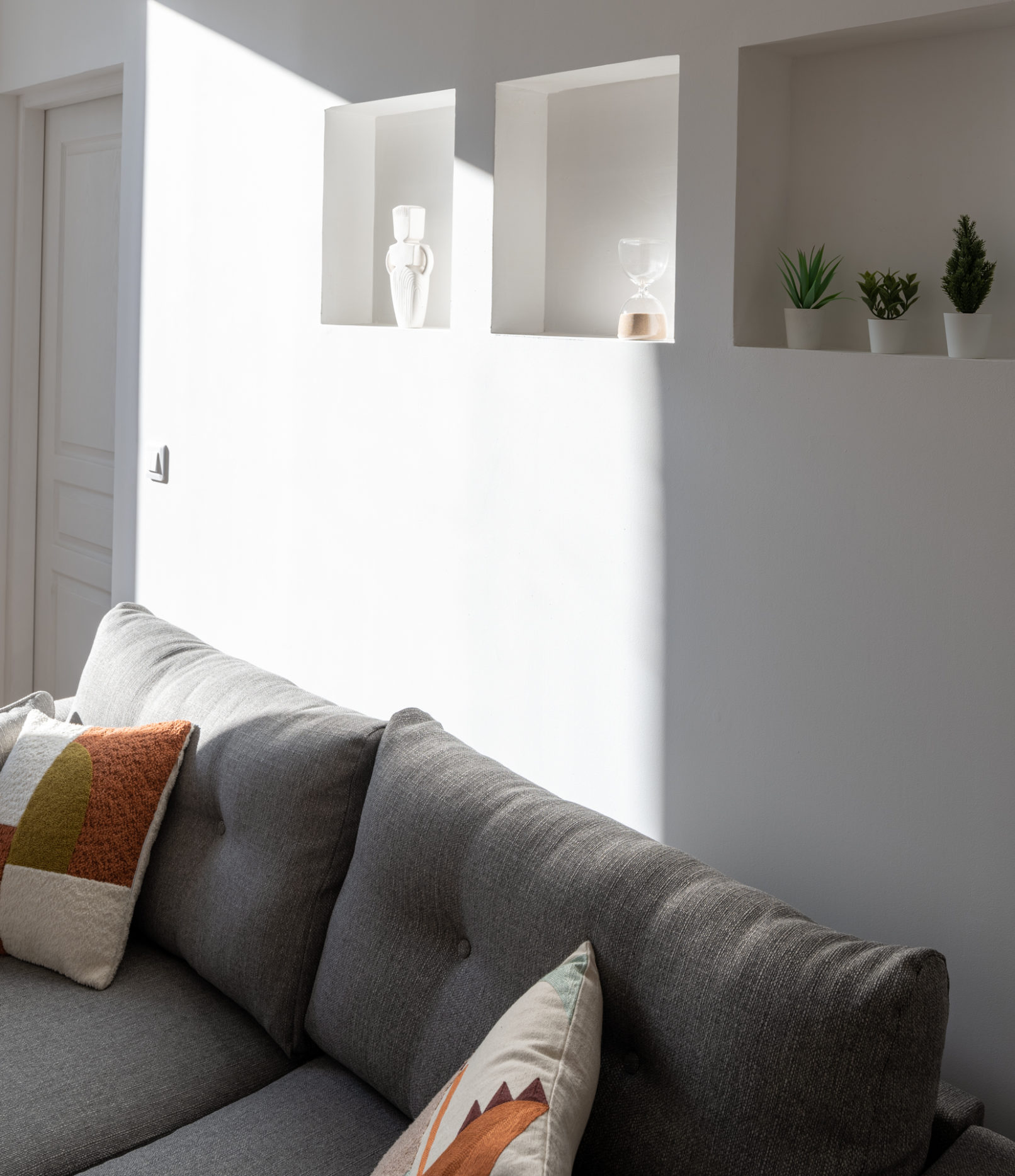 Niches avec objets décoratifs au dessus du canapé