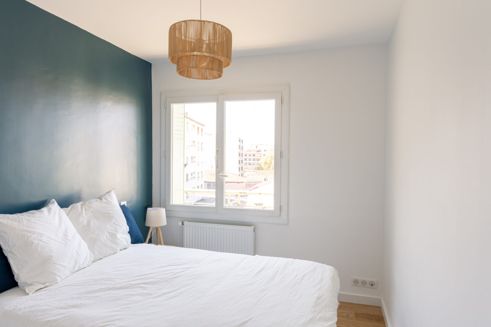 Chambre avec mur bleu canard, luminaire en bois