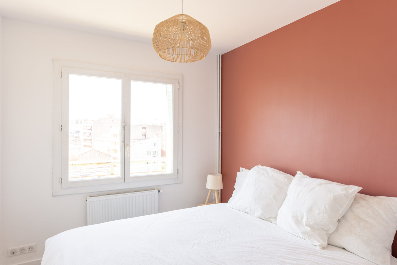 Chambre avec radiateur blanc, luminaire en bambou
